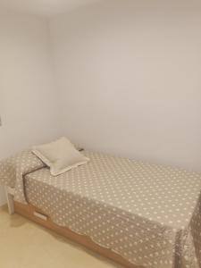 uma cama num quarto com uma parede branca em Casa Rural La Botica em Jarandilla de la Vera