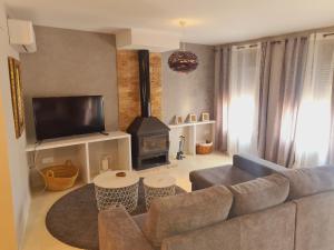 a living room with a couch and a stove at Casa Rural La Botica in Jarandilla de la Vera