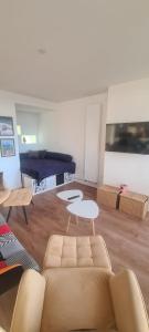 een woonkamer met een bank, tafels en een piano bij L'Appart! in Boulogne-sur-Mer