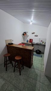 cocina con encimera y 2 taburetes en una habitación en Casa Temporada Beberibe en Beberibe