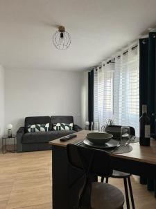 a living room with a table and a couch at cosy moderne chaleureux équipé proche tram in Talence