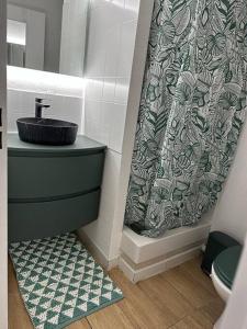 a bathroom with a sink and a shower curtain at cosy moderne chaleureux équipé proche tram in Talence