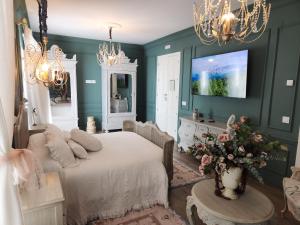 Hotel Boutique IULIA 5 Estrellas Premium في زافرا: غرفة نوم بجدران خضراء وسرير وتلفزيون