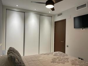 a bedroom with a bed and a flat screen tv at TECNOCORDOBA II aparcamiento privado gratuito y piscina in Córdoba