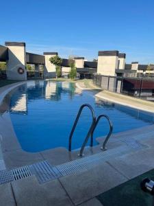 a swimming pool with two metal handles in a building at TECNOCORDOBA II aparcamiento privado gratuito y piscina in Córdoba