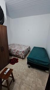um quarto com duas camas e uma mesa em Casa Temporada Beberibe em Beberibe