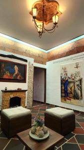 赫里科的住宿－El Quijote Apartahotel，客厅设有2张凳子和壁炉