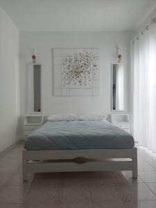 een witte slaapkamer met een groot bed. bij Blue Dolphin Studios and Apartment in Vaia