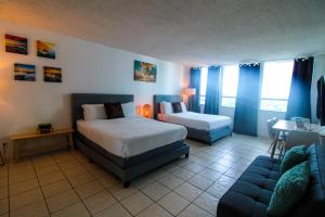 a hotel room with two beds and a couch at Castle 1205 Beachfront Studio with Free Parking, Beach Access, Pool, Tennis in Miami Beach +19 photos