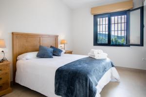 a bedroom with a large white bed and a window at Cortijo San Antonio de Trejo in Setenil +60 photos