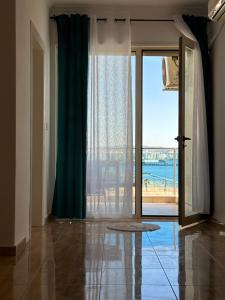 uma sala de estar com uma porta que abre para um pátio em Beach front Superior Apartment em Durrës