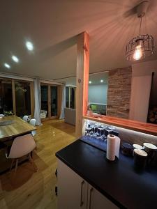 a kitchen with a counter top and a living room at Pine Cabins Zlatibor in Zlatibor