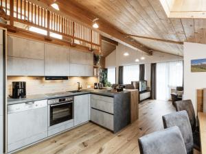 una cocina abierta con techos de madera y suelo de madera. en Alpenapartments, en Ried im Oberinntal