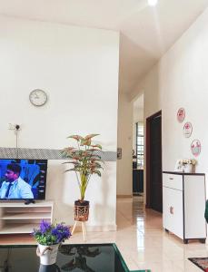 un soggiorno con una TV a parete di Malin's Homestay Kota Bharu a Kota Bharu