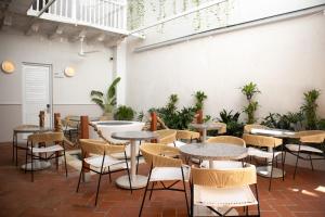 uma sala com mesas, cadeiras e plantas em Hotel Casa La Mantilla by Faranda Boutique em Cartagena das Índias