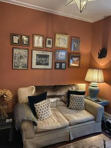 a living room with a couch and pictures on the wall at Charming & Spacious 2BD House wGarden - Wimbledon in Raynes Park