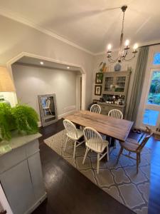 a dining room with a wooden table and chairs at Charming & Spacious 2BD House wGarden - Wimbledon in Raynes Park