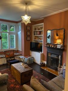 a living room with a fireplace and a tv at Charming & Spacious 2BD House wGarden - Wimbledon in Raynes Park