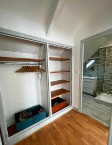 Zimmer mit einem Schrank mit Regalen und einem Fenster in der Unterkunft MAISON DE VILLE in La Haye-du-Puits