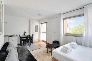 een witte kamer met een bed en een eetkamer bij Cosy Studio 2P - Parc Buttes Chaumont in Parijs