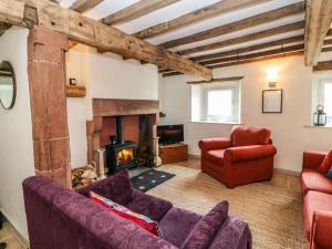 a living room with a couch and a fireplace at Croft Cottage in Long Marton
