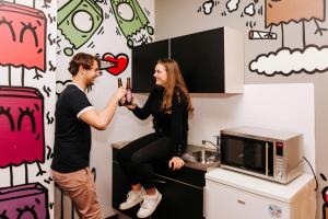 a man and a woman taking a picture in a kitchen at Amsterdam Teleport Hotel in Amsterdam