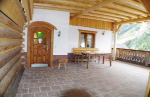 un porche con una puerta de madera y una mesa en Haus Breitfuss, en Enzenstall