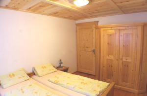 1 dormitorio con 2 camas y armario de madera en Haus Breitfuss, en Enzenstall