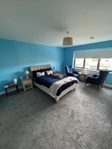 een slaapkamer met een bed en een blauwe muur bij 1 luxurious room in family home in Killarney