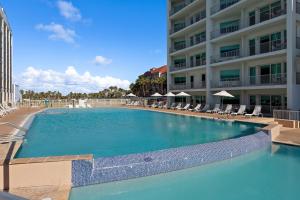 a large swimming pool in front of a building at Peninsula Island Resort & Spa - Beachfront Property at South Padre Island in South Padre Island