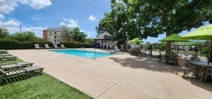a swimming pool with chairs and a table and umbrella at Quality Inn & Suites Garden Of The Gods in Colorado Springs
