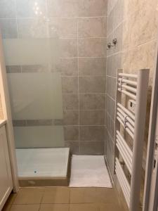 ein Badezimmer mit Dusche und Handtüchern auf dem Boden in der Unterkunft Cozy appartement en plein coeur de Dax Fontaine Chaude in Dax