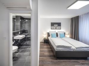 a bedroom with a large bed and a bathroom at Mood contemporary living in Mannheim