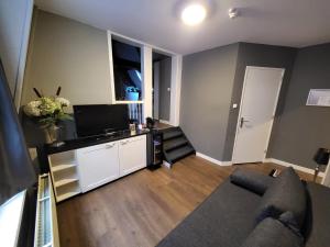 een woonkamer met een bank en een tv bij Hotel Broer & Zus in Den Haag