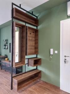 La salle de bains est pourvue de murs verts et d'étagères en bois. dans l'établissement Tilia Home, à Vrnjačka Banja