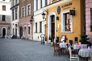 an empty street with tables and chairs in front of a building at Apartamenty Kamienica Muzyków Old Town Lublin in Lublin