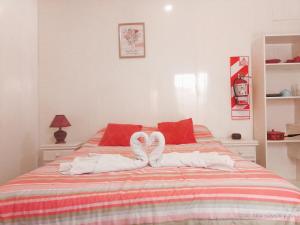 Un dormitorio con una cama con toallas blancas. en Zafiro Departamentos en Capilla del Monte