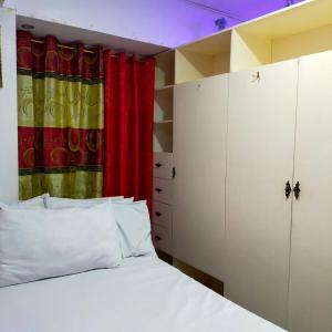 a bedroom with a bed and a red curtain at Cozy Condo Unit w/ FREE WIFI&Netflix-Pay Parking in Antipolo