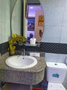 a bathroom with a sink and a toilet and a mirror at Cozy Condo Unit w/ FREE WIFI&Netflix-Pay Parking in Antipolo