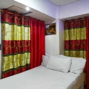 a bedroom with red and yellow curtains and a bed at Cozy Condo Unit w/ FREE WIFI&Netflix-Pay Parking in Antipolo