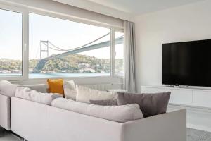 Bosphorus Mansion في إسطنبول: غرفة معيشة بيضاء مع أريكة بيضاء ونافذة كبيرة
