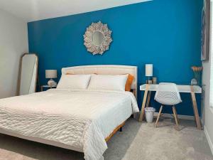 Dormitorio azul con cama y pared azul en Chanti’s Place, Winter Haven. Great Longterm Stay, en Winter Haven