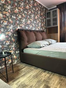 1 dormitorio con 1 cama y papel pintado con motivos florales en Hugo 3 en Jēkabpils