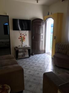 a living room with a brown door and a couch at Itanhaem - Casa com Piscina in Itanhaém