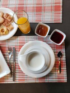 einen Tisch mit einem Teller Essen und einem Glas Orangensaft in der Unterkunft Hotel Maria in Encarnación