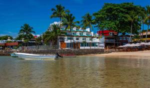 a boat sitting in the water next to a beach at Aqua by Sambass in Morro de São Paulo +45 photos