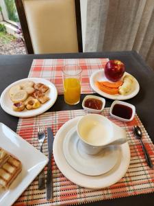 einen Tisch mit Speisen und einer Tasse Orangensaft in der Unterkunft Hotel Maria in Encarnación