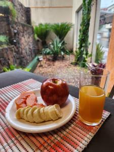 einen Obstteller, einen Apfel und ein Glas Orangensaft in der Unterkunft Hotel Maria in Encarnación