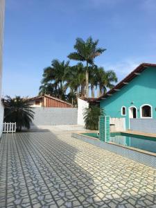 a cobblestone street in front of a blue building at Itanhaem - Casa com Piscina in Itanhaém