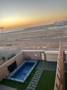 a building with a swimming pool next to a beach at شاليهات الأحلام in Rayyis